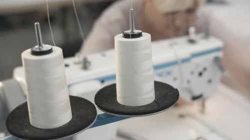 A Closeup View of Colorful Thread Spools and a Sewing Machine Inside a Tailor Workshop
