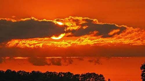 Sunset Behind Clouds with Orange Sky