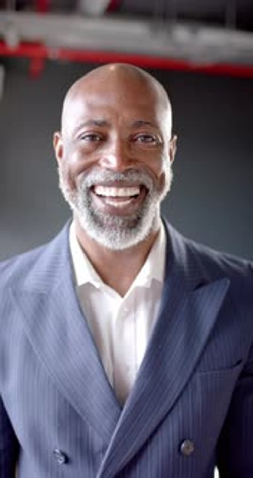 Vertical video of smiling african american businessman in office with copy space
