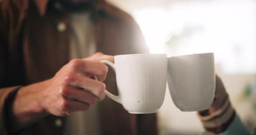 Close Up of Hands Clinking Mugs Together