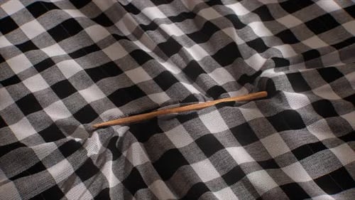 Fluid Movement of Checkered Fabric by Wooden Stick