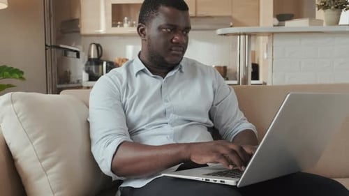 Man Working on Laptop at Home