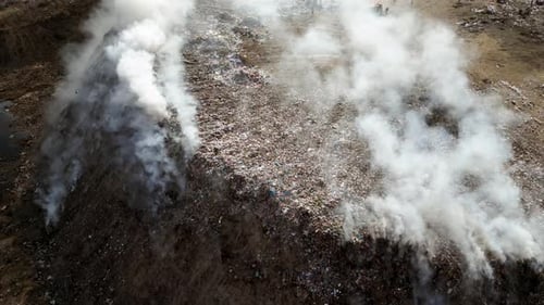 Aerial view of landfill with burning trash piles