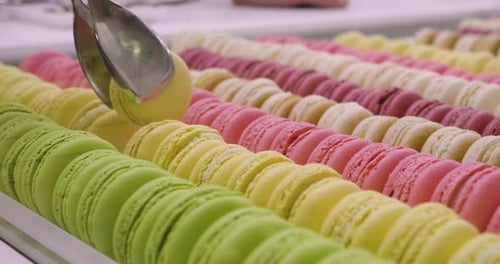 Colorful Macarons in Rows with Silver Tongs