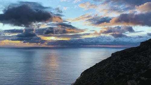 Wunderschöner Sonnenuntergang in der goldenen Stunde auf See mit dramatisch Himmel und Sonnenstrahlen zwischen den Wolken