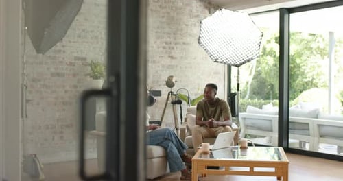 Deux co-animateurs adultes, un homme entrant, une femme parlant, faisant des gestes, enregistrant en home studio avec micro