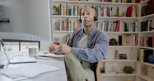 Man Attends Meeting Wearing Headset in Home Office