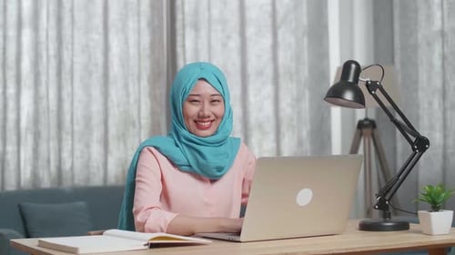 Woman Using Laptop at Desk in Home Office