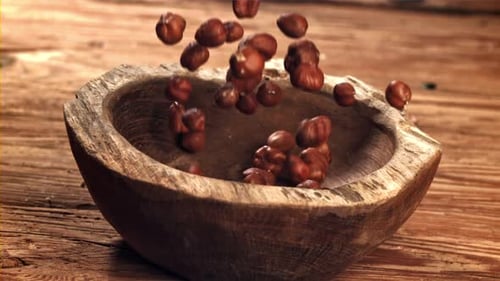 Hazelnuts Fall Into a Wooden Bowl Filmed on a Highspeed Camera at 1000 Fps