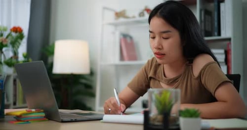 Young Adult Studying at Desk with Laptop