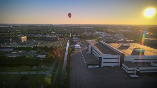Hot air balloon in a beautiful sunset. Hot air balloon floating over a city filled with beautiful go