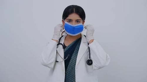 Smiling Woman Doctor Removing Surgical Mask