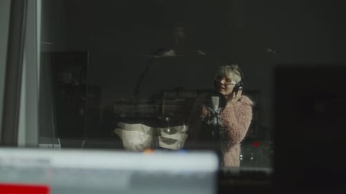 Female Singer Recording Vocals in Professional Music Studio Booth