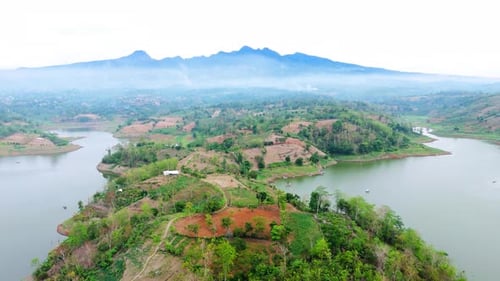 Drone footage of natural lake landscape with forest land and mountain