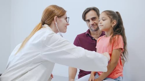 Doctor Checking Little Girl with Father Present