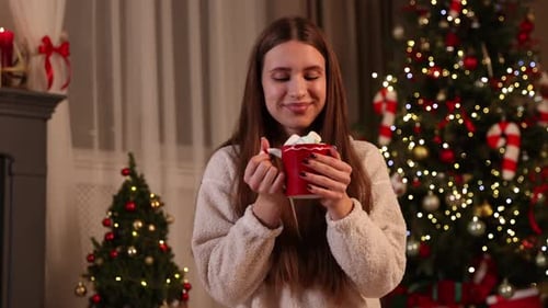 Smiling Woman Holding Mug of Hot Chocolate at Christmas
