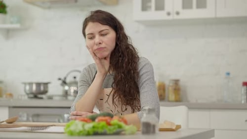 Woman Thinking About Recipe Ingredients in Kitchen