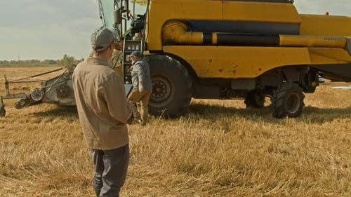 Group Of Farmers in Wheat Field Discussing Operation