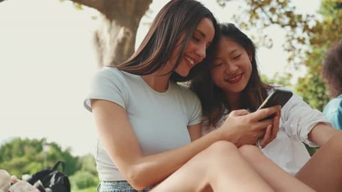 Friends Looking at Phone in a Park