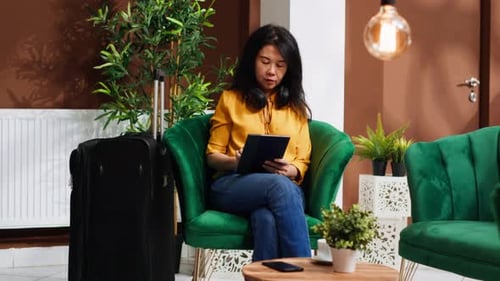 Young Traveler Using Tablet in Lounge Area at Hotel