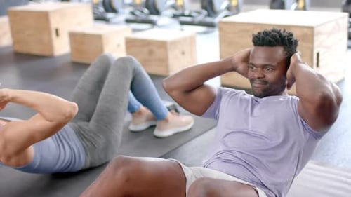 Fit diverse couple rests after a workout at the gym