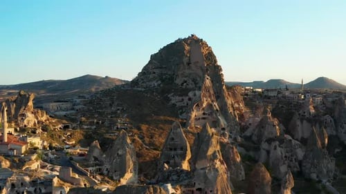 Aerial rise over Uchisar castle, carved into landscape of Cappadocia, Turkey