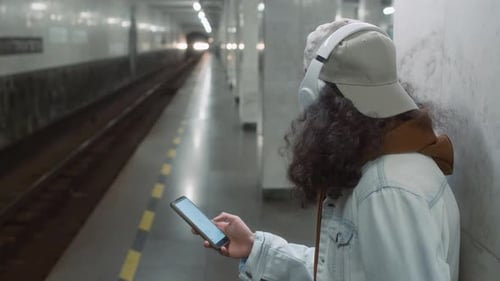Guy Waiting for Arriving Train and Looking at Chroma Key Phone Screen