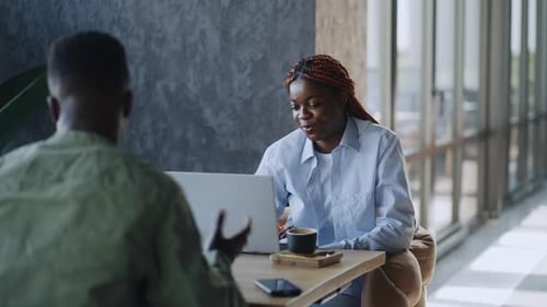Two Smiling Business Partners a Man and a Woman Discussing Work Over Coffee in a Cafe