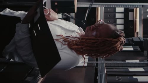 Woman Looks at Files in Office Storage Room