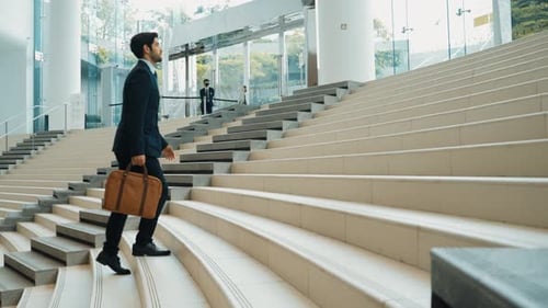 Professioneller Geschäftsmann, der die Treppe hinaufgeht. Repräsentiert Reisen. jubelnd.