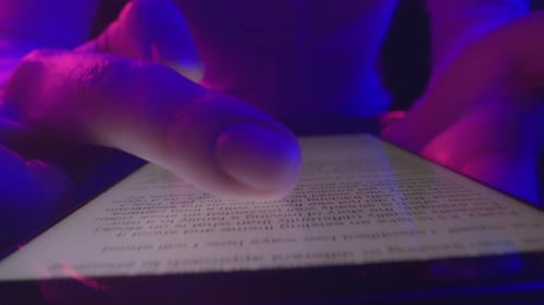 Woman's hands scroll news feed on smartphone screen in vibrant neon lighting