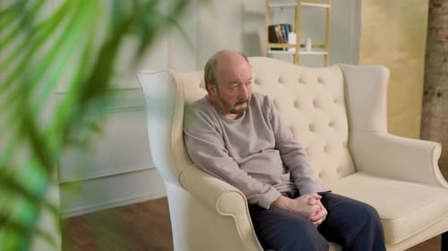 Man Sitting Alone, Lost in Thought on Sofa