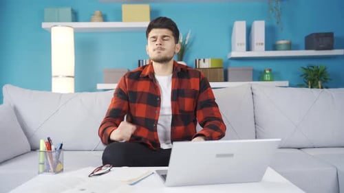 Young Adult Frustrated While Using Laptop At Home