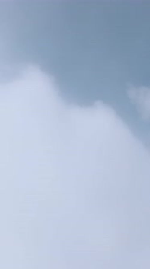 Vertical Video Serene View of Floating Cloud Layers and Mist with Gentle Textures and a Bright Blue