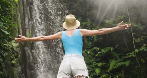Woman Enjoying Waterfall in Lush Tropical Rainforest