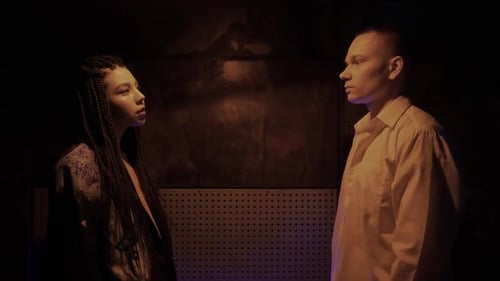 Young Adults Talking Indoors Under Dark Lighting