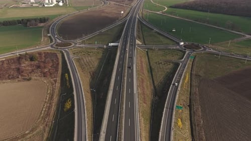 A high-angle aerial view of a highway interchange surrounded by agricultural land.