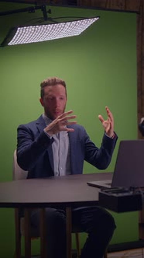 A Professional Speaker Engages an Audience in a Dynamic Front of a Green Screen Setup