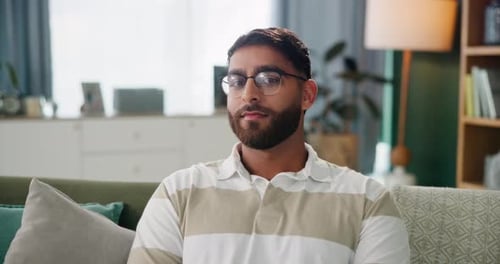 Indian man, face and relax in home for peace, glasses and laugh for funny joke or humor in lounge