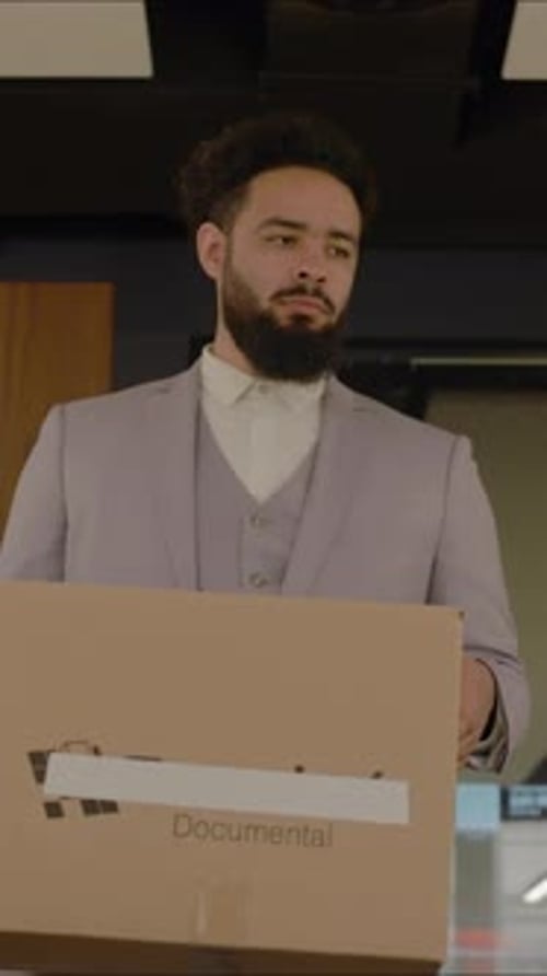 Um empresário deprimido carregando uma caixa pesada após ser demitido de seu escritório