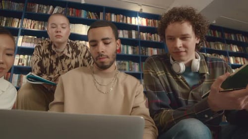 College Students Searching for Information Online on Laptop in Library