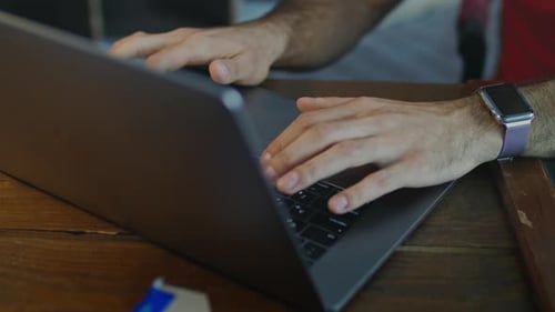 Businessman hands typing on macbook keyboard at home office late at night