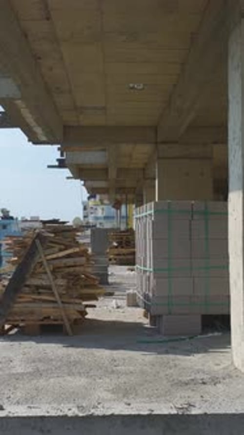 Vídeo vertical: perspectiva aérea de los trabajadores que se dedican a la construcción de muros y la manipulación de materiales en un