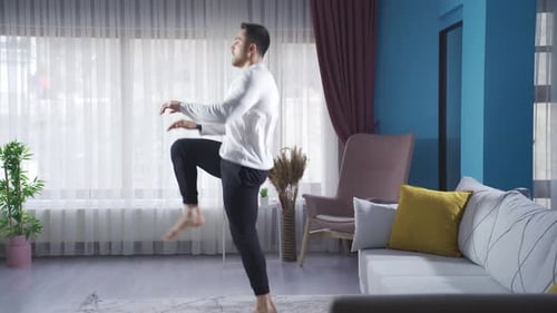 Der junge Sportler trainiert zu Hause, indem er seine Beine schnell und flott zu sich zieht.