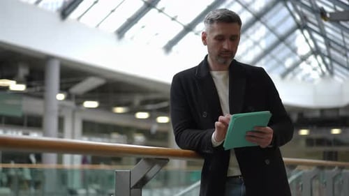Man Works on Tablet in Modern Urban Space