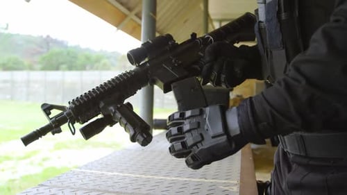 Person Loads Rifle at an Outdoor Shooting Range