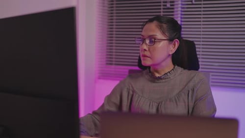 Nahaufnahme einer arbeitenden Programmiererin und großer Computerbildschirm mit Programmlinien