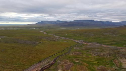 Terrazas de piedra de Curving Creek y tundra con montículos cerca de Lavrentiya Arctic