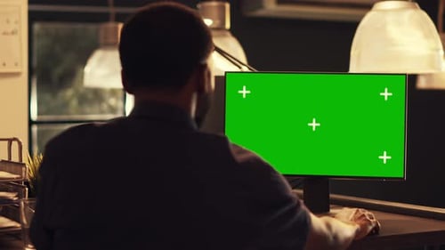 Successful Office Worker Analyzing Computer Monitor with Greenscreen