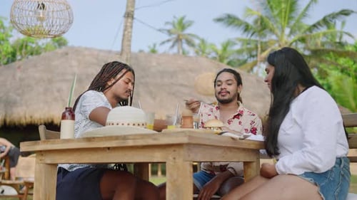 Multiracial LGBTQ Friends Laugh Eat Chat at Sunny Beachside Cafe Group Enjoys Burgers Drinks
